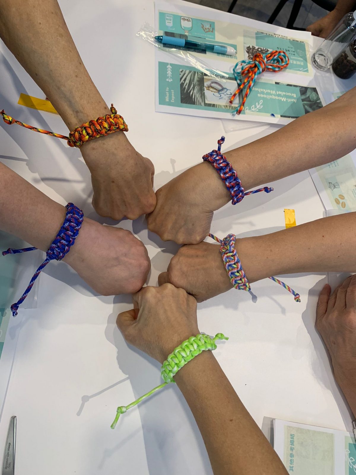 Five hands with event bracelets